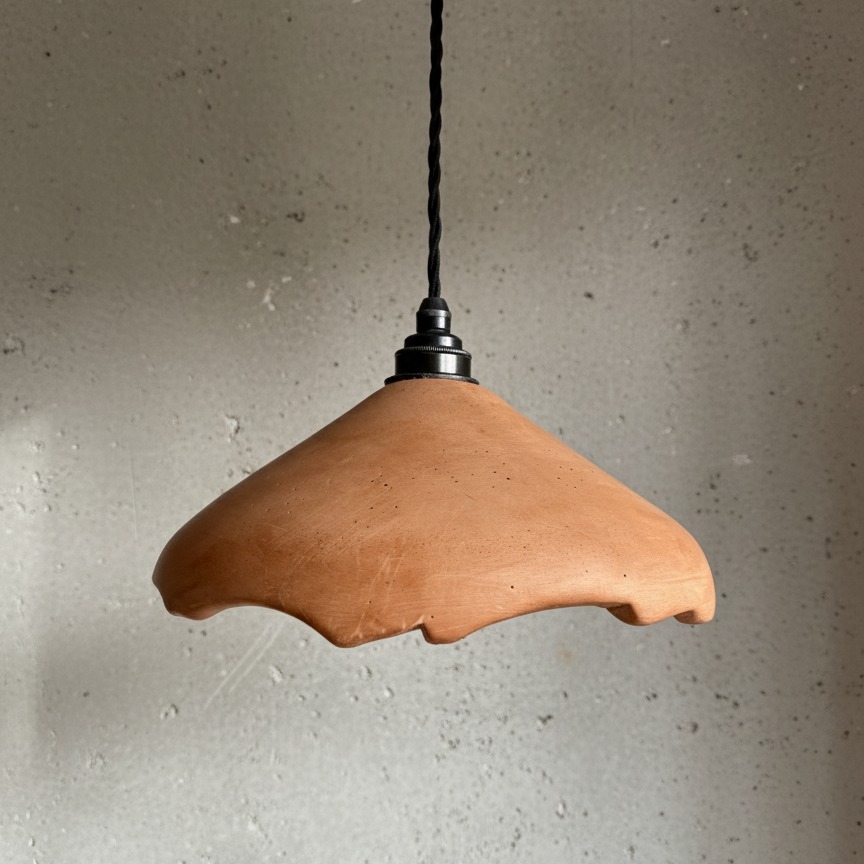 Terracotta pendant light against a gray wall