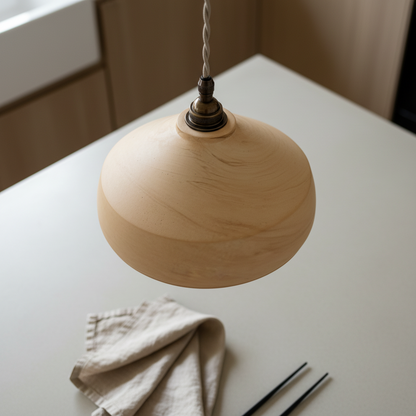 Handmade sandstone pendant light on a white surface with a neutral background