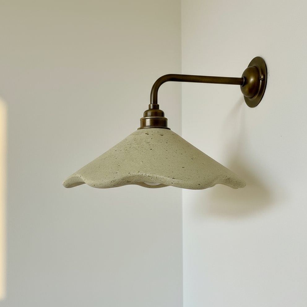 Wall-mounted light fixture with a concrete-like shade on a white wall.
