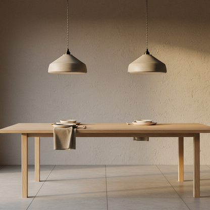 Dining table with two pendant lights in a minimalistic room.