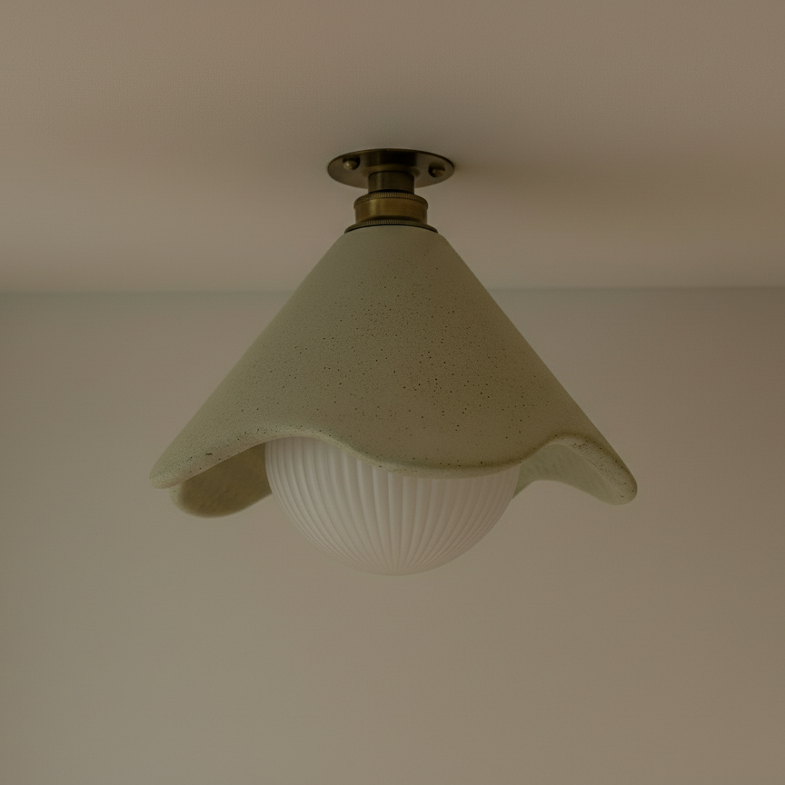 Ceiling light fixture with a glass shade on a plain wall.